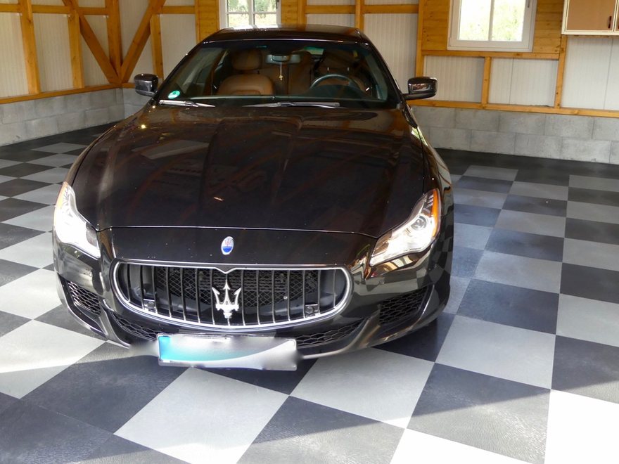 Sportwagen in einer Garage auf einem Boden im Schachbrettmuster