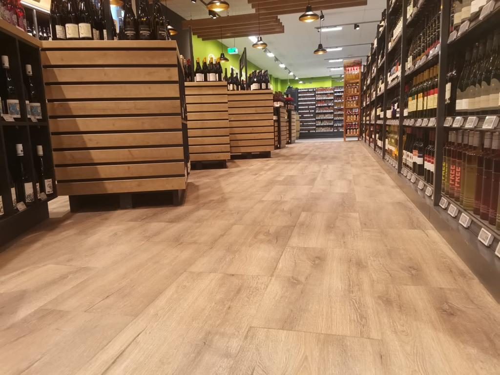Weinabteilung mit Holzregalen auf Boden in Eichenoptik