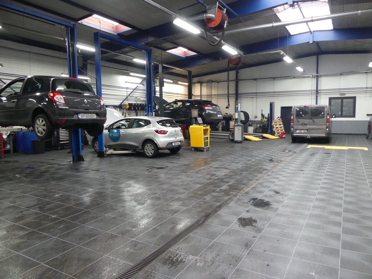Kfz-Werkstatt mit Hebebühnen und dunklem Bodensystem