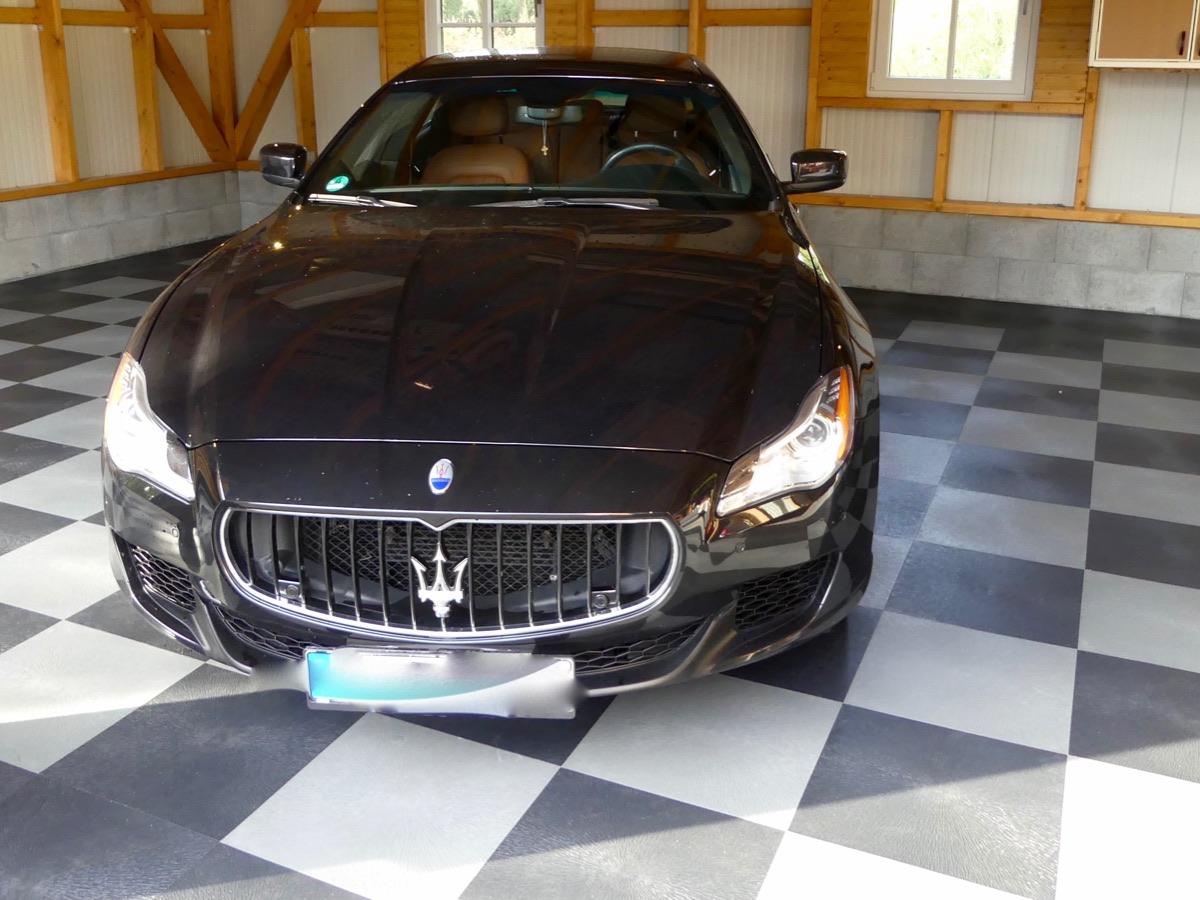 Sportwagen in einer Garage auf einem Boden im Schachbrettmuster